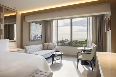 a bedroom with a bed and a living room at El Embajador, a Royal Hideaway Hotel in Santo Domingo