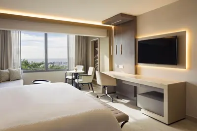 a hotel room with a bed and a desk with a television at El Embajador, a Royal Hideaway Hotel in Santo Domingo