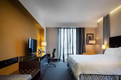 a hotel room with a bed and a television at Holiday Inn Santo Domingo by IHG in Santo Domingo