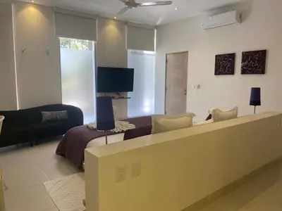 a living room with a couch and a television at CASA-22 Luxury Boutique Hotel in Sosúa