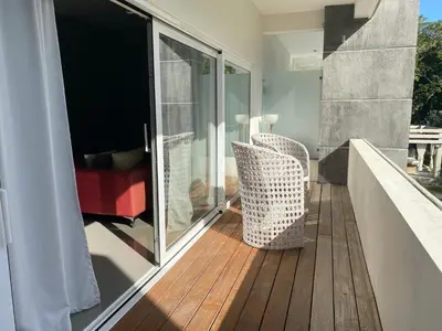 a balcony with two chairs on a wooden deck at CASA-22 Luxury Boutique Hotel in Sosúa
