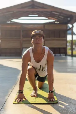 a man kneeling on a yoga mat in a gym at El Encuentro Surf Lodge in Cabarete