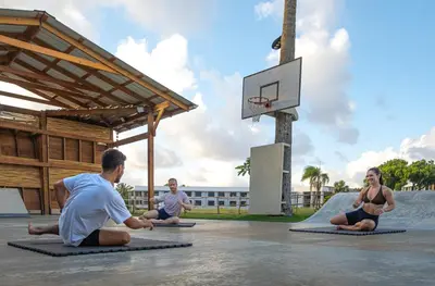 a group of people sitting around a basketball hoop at El Encuentro Surf Lodge in Cabarete