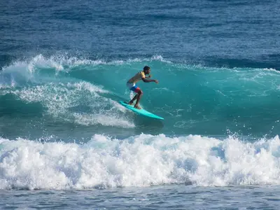 a man riding a wave on a surfboard in the ocean at El Encuentro Surf Lodge in Cabarete
