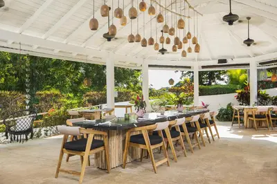 a dining room with a long table and chairs at El Encuentro Surf Lodge in Cabarete