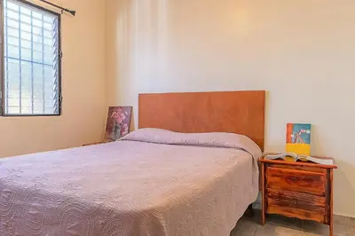 a bedroom with a bed with a wooden headboard and a table at D'Piero Hotel in Sosúa