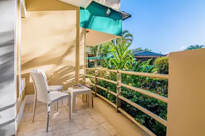 a balcony with two chairs and an umbrella at D'Piero Hotel in Sosúa
