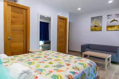 a bedroom with a bed and a couch at Villa Elegante y Familiar en Pedernales, Cerca de la Playa del pueblo, Residencial SFA in Pedernales