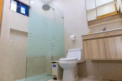 a bathroom with a toilet and a glass shower at Villa Elegante y Familiar en Pedernales, Cerca de la Playa del pueblo, Residencial SFA in Pedernales