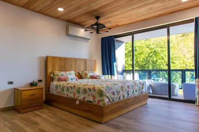 a bedroom with a bed and a large window at Villa Elegante y Familiar en Pedernales, Cerca de la Playa del pueblo, Residencial SFA in Pedernales