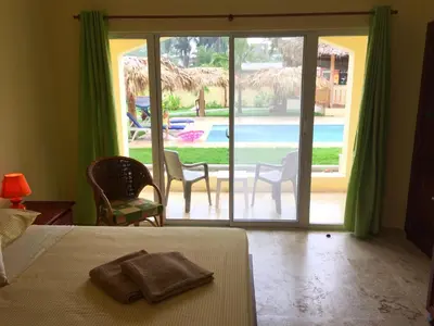 a bedroom with a bed and a view of a pool at Las Galeras Hotel in Las Galeras