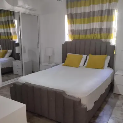 a bedroom with a large bed with yellow pillows at Nely y Pietro share apartment in Punta Cana