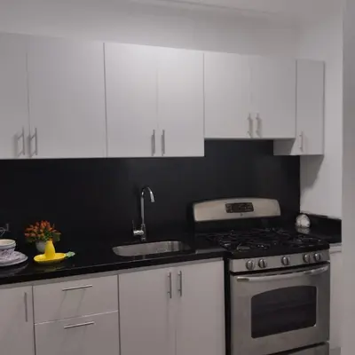a kitchen with white cabinets and a stove top oven at Nely y Pietro share apartment in Punta Cana