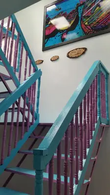a blue staircase with a painting on the wall at Hostal Johnnier Macao Punta Cana in Punta Cana