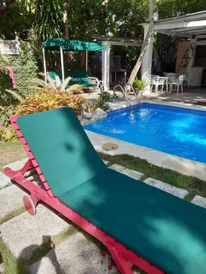 a pool table next to a swimming pool at Villa Carolina Bed and Breakfast in San Felipe de Puerto Plata