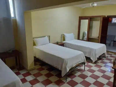 a room with two beds and a checkered floor at Villa Carolina Bed and Breakfast in San Felipe de Puerto Plata