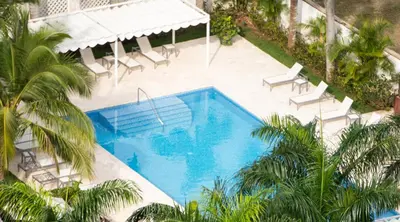 an overhead view of a swimming pool with palm trees at Hotel Casa Hemingway in Juan Dolio