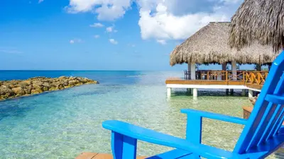 a blue chair sitting on a beach near the ocean at Hotel Casa Hemingway in Juan Dolio