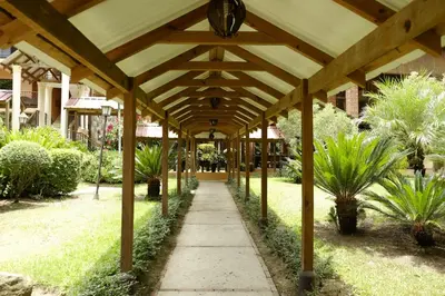 a wooden pavilion in a garden with palm trees at Hotel Gran Jimenoa in Jarabacoa