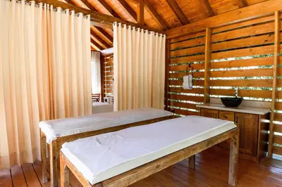 a room with two beds in a room with wooden walls at Hotel Gran Jimenoa in Jarabacoa