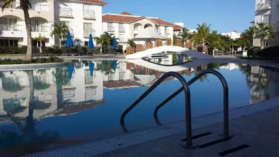 a pool of water with buildings and palm trees at Appartamento Cadaques Bayahibe in Bayahibe