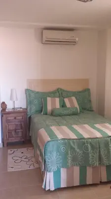 a bedroom with a bed with a green comforter at Appartamento Cadaques Bayahibe in Bayahibe