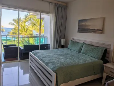 a bedroom with a bed and a view of the ocean at Seawinds Studio - Beachfront Getaway in Cabarete