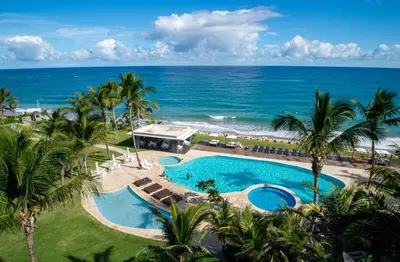 an aerial view of a resort pool and the ocean at Seawinds Studio - Beachfront Getaway in Cabarete