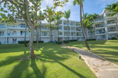 a large building with palm trees in front of it at Seawinds Studio - Beachfront Getaway in Cabarete