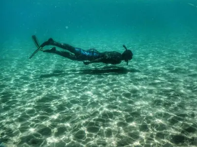 a man is swimming in the water in the ocean at Ocean Front Two Bedroom Penthouse in Sosúa
