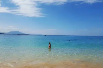 a woman standing in the water at the beach at Ocean Front Two Bedroom Penthouse in Sosúa