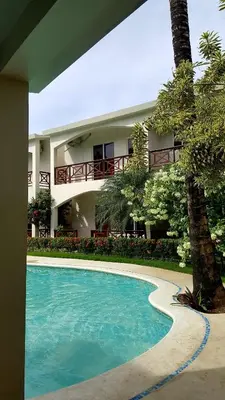 a house with a swimming pool in front of a building at Apartamento en Las Terrenas in Las Terrenas