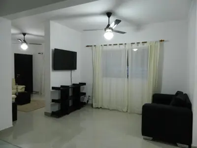 a living room with a television and a couch at Residencial Vista Del Bosque in Santiago de los Caballeros