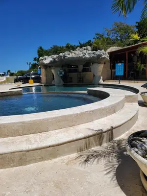 a swimming pool with a fountain in a park at Susy paradise in Sosúa