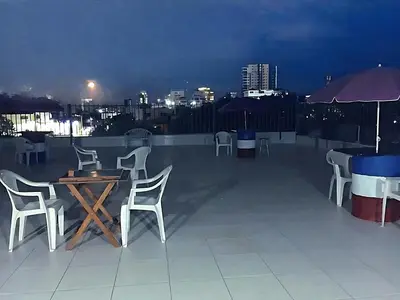 a table and chairs on a rooftop at night at Miami Studios DR in Santo Domingo