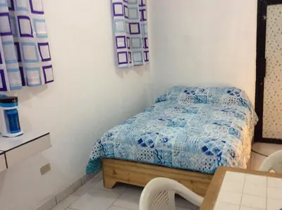 a bedroom with a bed and a table and chairs at Miami Studios DR in Santo Domingo