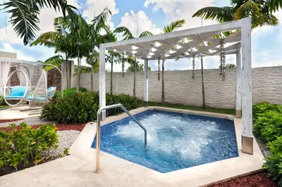 a hot tub in a backyard with a pergola at Catalonia Royal La Romana Adults Only - All Inclusive in Bayahibe