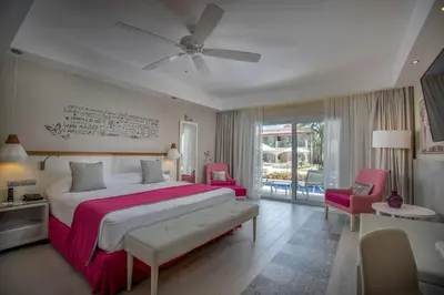 a bedroom with a large bed with a red blanket at Catalonia Royal La Romana Adults Only - All Inclusive in Bayahibe