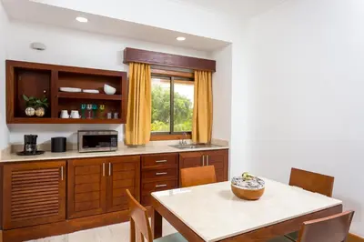 a kitchen with wooden cabinets and a table and a window at Tot Punta Cana Apartments in Punta Cana