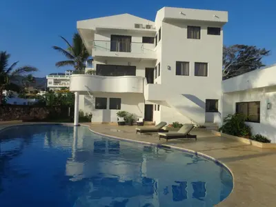 a house with a swimming pool in front of a building at White House Mansion in San Felipe de Puerto Plata