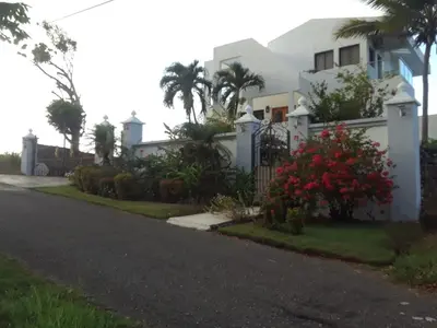 a white house with a fence and a driveway at White House Mansion in San Felipe de Puerto Plata