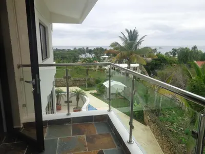a balcony with a view of the ocean at White House Mansion in San Felipe de Puerto Plata