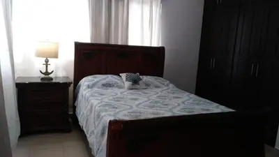 a bedroom with a bed and a lamp and a window at White House Mansion in San Felipe de Puerto Plata