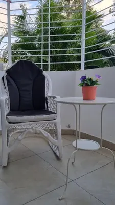 a white chair sitting next to a table with a plant at Villa Roberta in Boca Chica