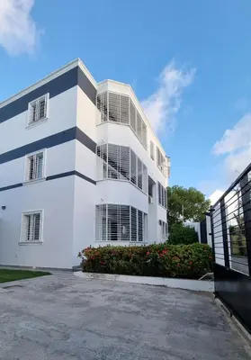 a white building with a parking lot at Villa Roberta in Boca Chica