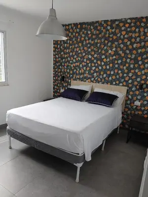 a large bed in a bedroom with a wall with avertisement at Villa Roberta in Boca Chica