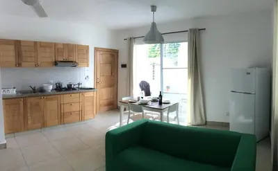 a living room with a green couch and a kitchen at Villa Roberta in Boca Chica