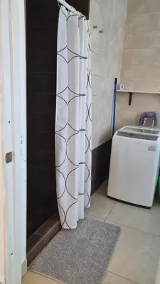 a shower curtain in a bathroom next to a washing machine at Villa Roberta in Boca Chica