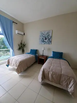 a bedroom with two beds and a window at Hidden Paradise at Apto Del Cerro in Santa Bárbara de Samaná