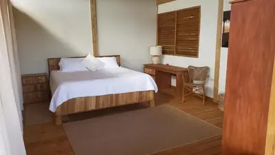 a bedroom with a bed and a table and a window at Eco Del Mar in Pedernales